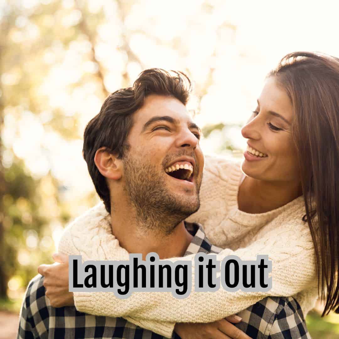 A couple enjoying a moment outdoors, with the woman playfully leaning on the man's back. Both are smiling amidst a sunlit, bl