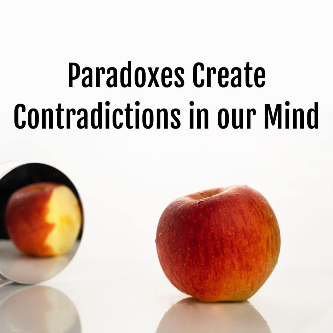 A bitten apple is placed next to a mirror, reflecting a whole apple with no bite. The text "Life Paradoxes Create Contradicti